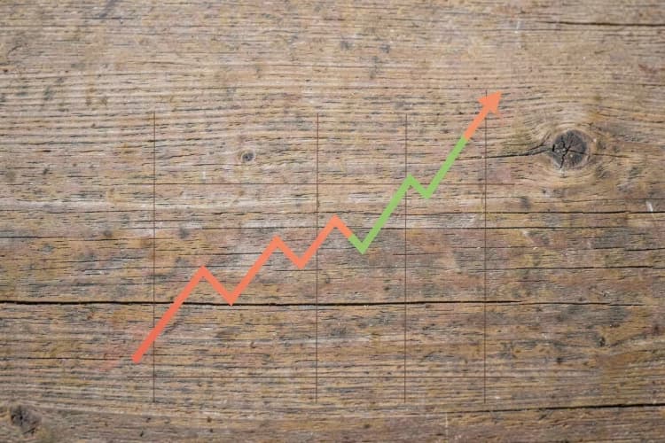 Gráfico de linha ascendente sobre fundo de madeira rústica, representando crescimento financeiro