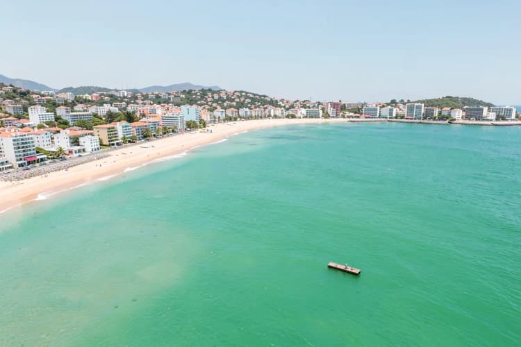 Vista aérea de Balneário Piçarras com praia, mar e construções, dia ensolarado