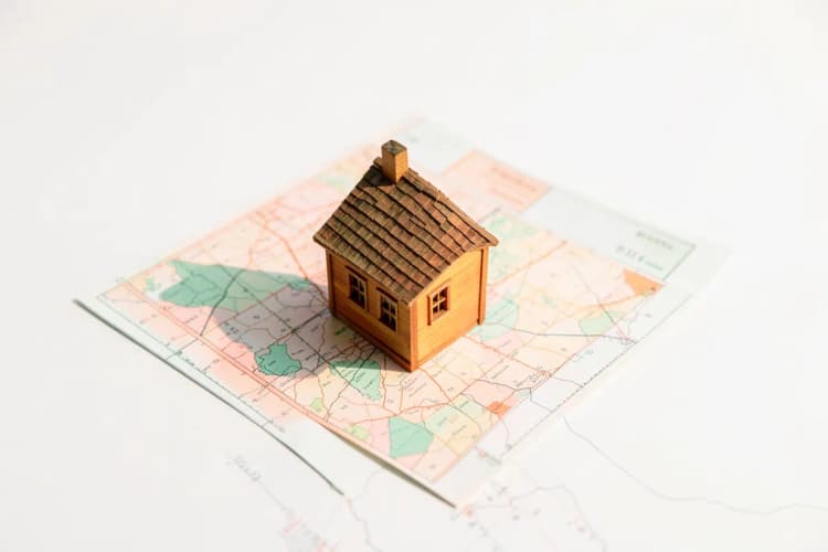 Uma casa em miniatura em cima de um mapa.