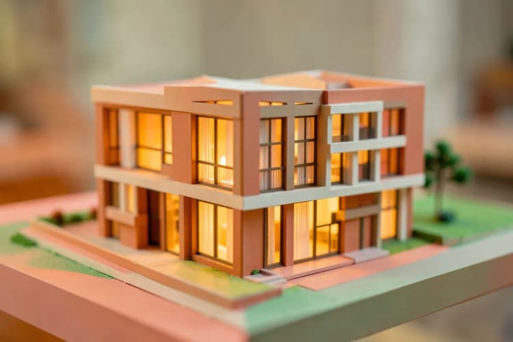 Uma maquete de um prédio residencial moderno com iluminação interna suave.