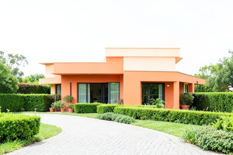 Fachada de uma casa grande e moderna com jardim bem cuidado.