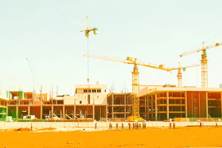 Construção de um prédio com guindaste e trabalhadores ao fundo