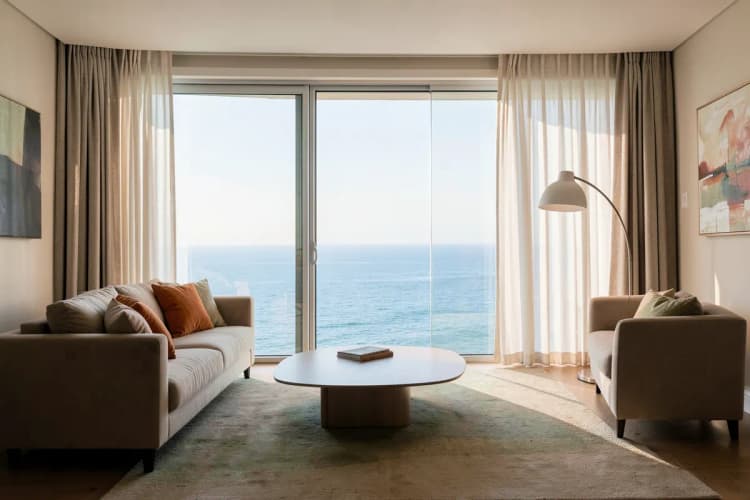 Sala de estar sofisticada com móveis elegantes e vista panorâmica para o mar