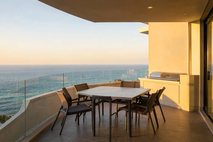 Varanda gourmet com churrasqueira e vista para o mar em um apartamento de luxo